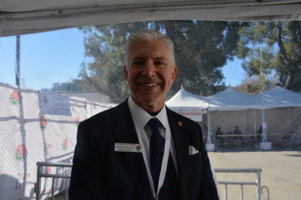 Jason Melillo, in suit and tie, smiles outside "Decorating Places" 48 hours prior to the Rose Parade®