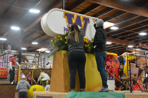 Volunteers glue materials to the big "W" on the University of Washington Rose Parade® football float