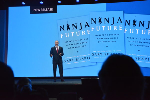 Gary Shapiro onstage in front of a slide with his new book, "Ninja Future"