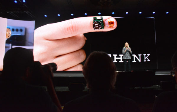 Ginni Rometty before a slide with a fingertip and sensor 