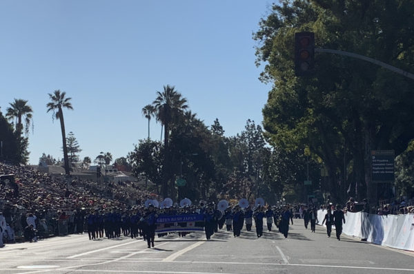 The Gree Band, with instruments, approaches from a distance behind b blue banner reading "Green Band Japan"