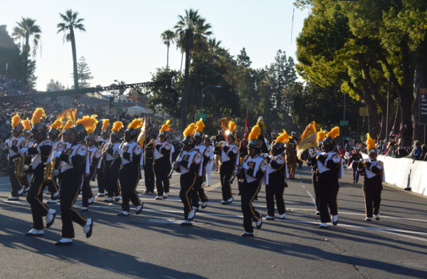 African-American band in black uniforms with gold plumes and white spats plays as they march down Orange Grove Boulevard