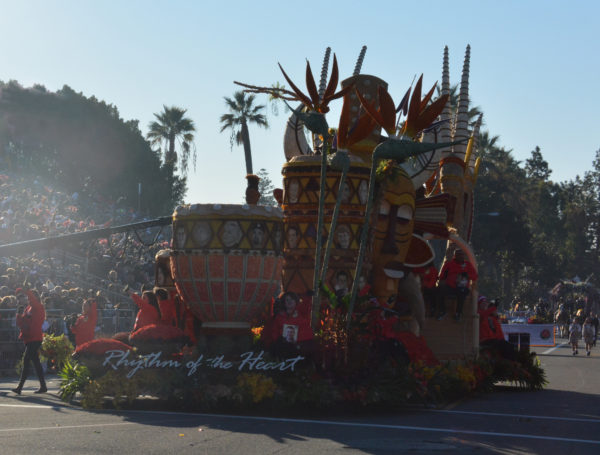 Closeup of float with double African mask, two towering drums at the front and three antelope at the back, entitled "Rhythm of the Heart"