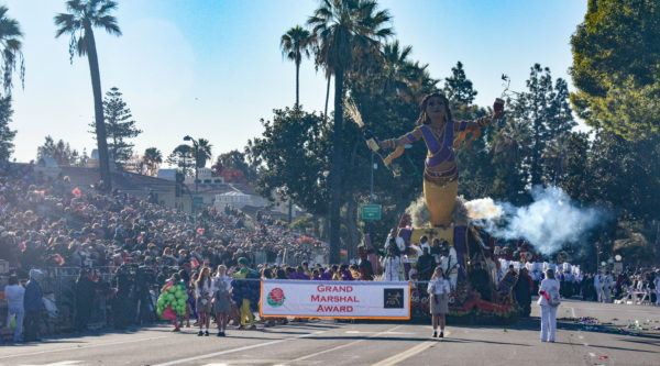 Stella Rosa float, with genie flying in the air, rolls past audience behind a banner reading "Grand Marshal Award"