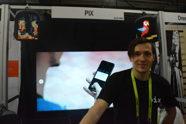 Pix creator Alex with a lightup backpack featuring a parrot and one with a mask as well as a video about his creation at Eureka Park