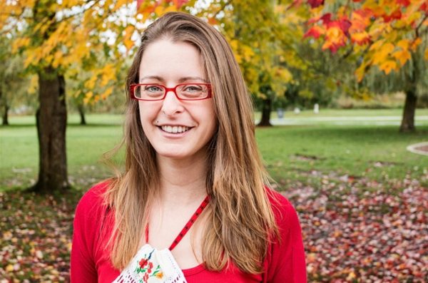 Makers Making Change Project Manager Zee Kesler in a park setting with gold-leafed trees in the background