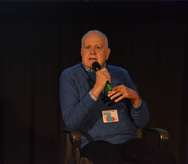 Tom Norris speaks on mic during Virtual Medicine conference, 2019