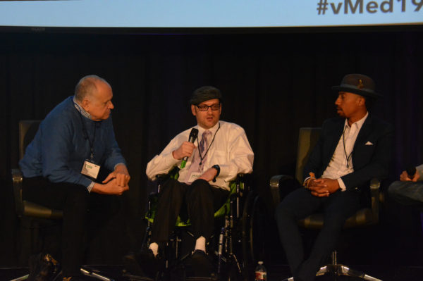 Jason discusses ways medical VR could improve from stage as fellow panelists Harmon Clarke and Tom Norris listen during Virtual Medicine 2019