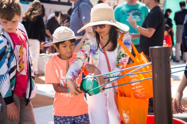 Mom and son test slingshot contraption at OC Steam Fest