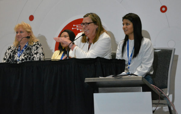 Melanie smiles and gestures as her fellow panelists smile during Women in Sensors Engineering panel