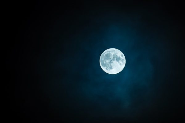 full moon surrounded by stars in a night sky