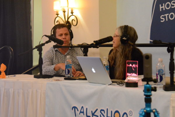 Dot listens as StangSat lead mentor Shaun Daly discusses the process of building the satellite at the Talkshoe pavilion