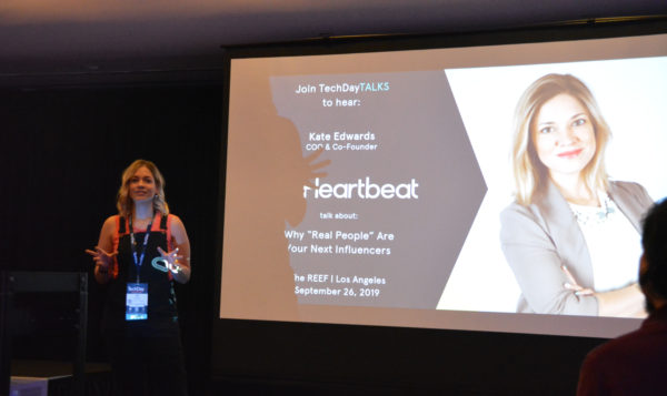 Heartbeat CEO Kate Edwards speaks next to a slide with her picture and "