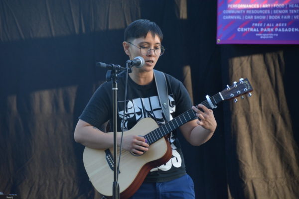 Closeup of Ace singing and playing guitar at San Gabriel Valley Pride