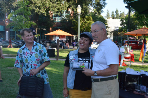 Mitch Braiman and Jessica Amaya pose with winner of 1967-1865 Open Car Ccategory as he holds trophy