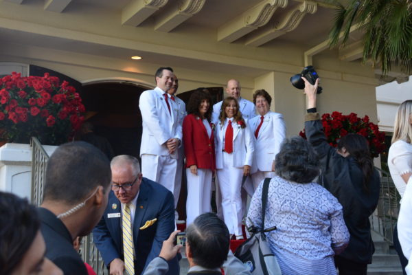 2020 Tournament of Roses President Laura Farber poses with Queen and Court Committee Chair Ruth Martinez-Baenen and White Suiters on Tournament House steps