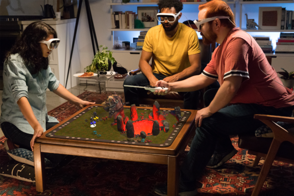 Three gamers wear augmented-reality glasses as they play a game with Tilt Five's holographic gaming system