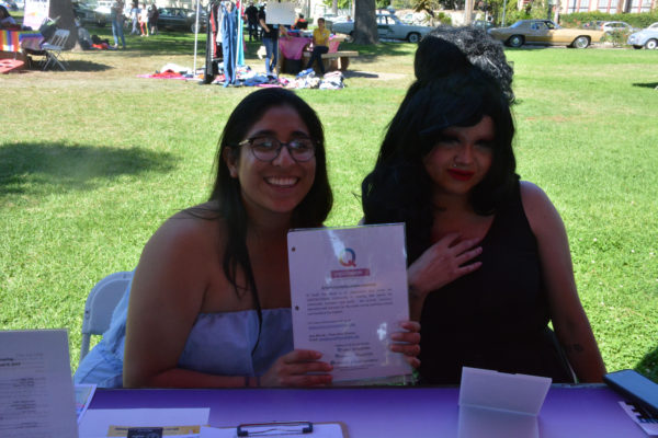 Q Youth Foundation staff hold up mission statement at San Gabriel Valley Pride 2019