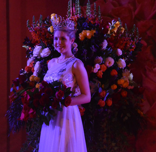 Rose Queen® Camille Kennedy with bouquet of red roses and crown on her head