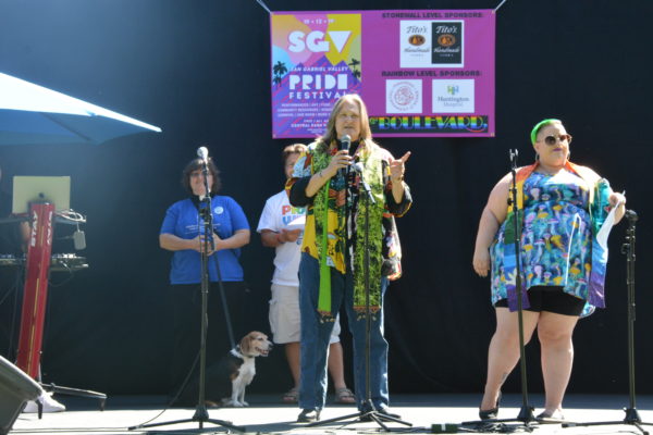 Reverend Pat speaks as three other spiritual leaders stand by onstage