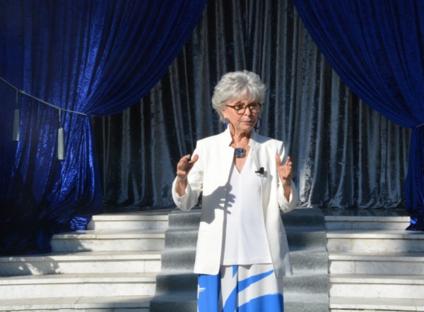 Rita Moreno gestures as she speaks from stage during Grand Marshal announcement