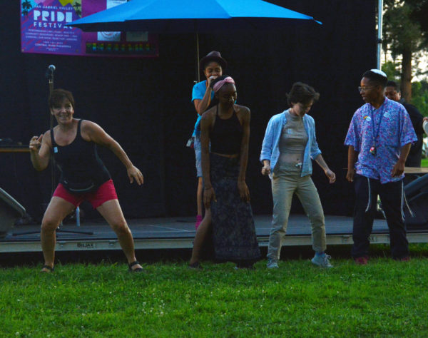 YaNI onstage performing as dancers dance at San Gabriel Valley Pride