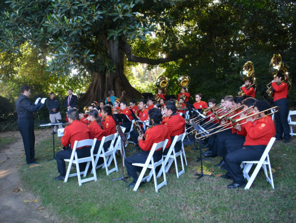 Tournament of Roses Honor band, in red jackets, plays under a tree in Tournament House garden