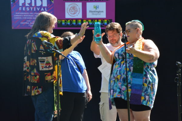 Four spiritual leaders bless a bottle of water onstage