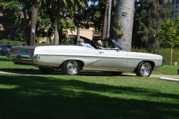 Driver backs a silver convertible with a Halloween skeleton in the passenger seat into Central Park for SGV Pride 2019