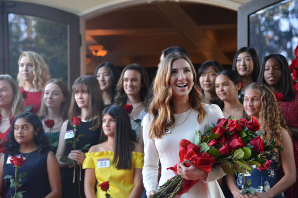 New Royal Court member Cole Fox reacts as she holds her bouquet of red roses