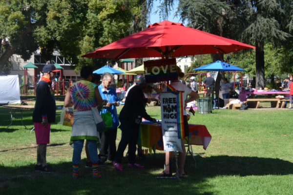 LOVE rainbow sign on Mom Hugs exhibit with SGV Pride tents in the background