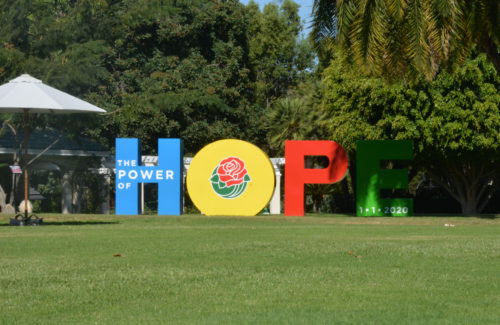 tall letters spell out the word "HOPE" on Tournament House lawn, with a red rose in the "O"