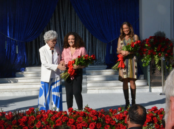 Rita Moreno takes roses from a laughing Laurie Hernandez as Gina Torres looks on