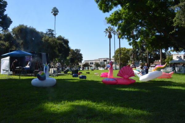 inflatable plastic unicorns and pink flamingo in the grass before SGV Pride 2019 stage area