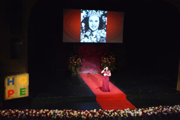 Margaret Huntley Main's picture flashes onscreen as 1940 Rose Queen® as Lynette Romero stands onstage