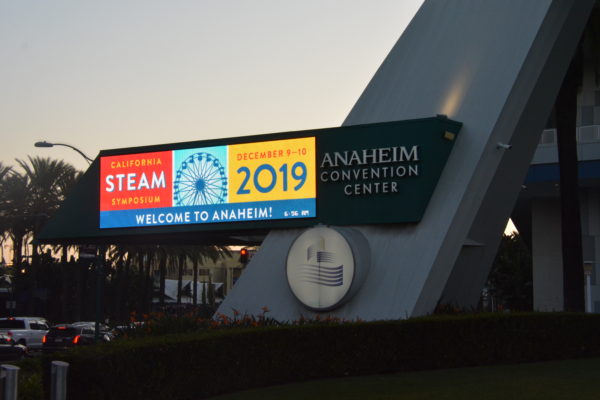 Sunrise over "California STEAM Symposium" sign on Anaheim Convention Center marquee