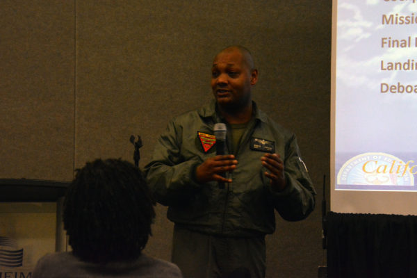 Khieem Jackson, dressed in a flight suit, co-leads a supersession on "Authentic STEAM Experiences" during California STEAM Symposium 2019
