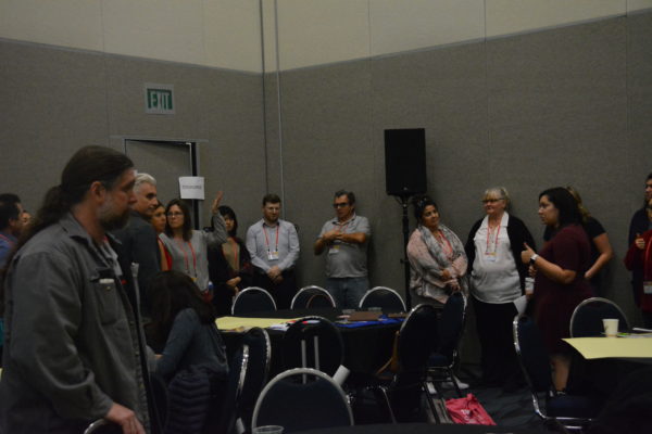 Seven or eight attendees line the wall next to a "Disagree" Post-It at California STEAM Symposium 2019