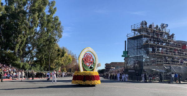 Rose Parade red rose symbol closes the parade as it passes the reviewing stand