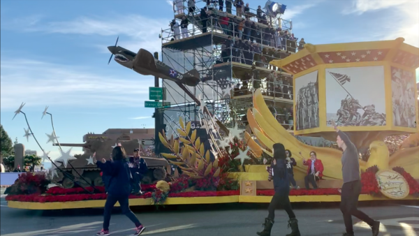 Replica of USS Indianapolis sits on front of CAHF float as outwalkers walk beside it at the corner of Colorado and Orange Grove