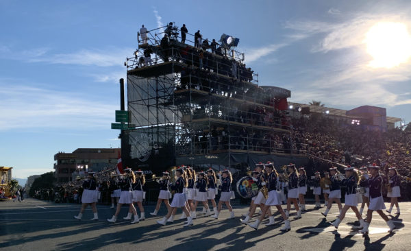 Danish band, in sailor suits with white pleated skirts and tams, march by reviewing stand playing woodwinds