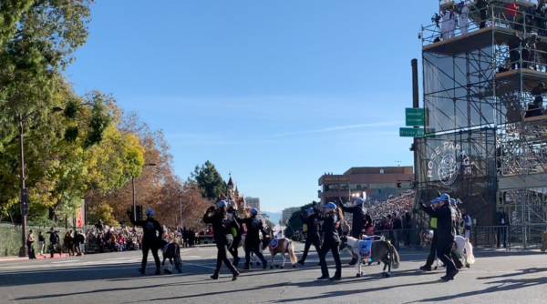 Parade participants wave as they lead six minature horses past the reviewing stand