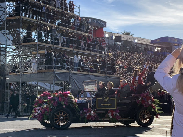 Tournament of Roses President Laura Farber beams from back of 1911 Rolls Royce approaching the reviewing stand