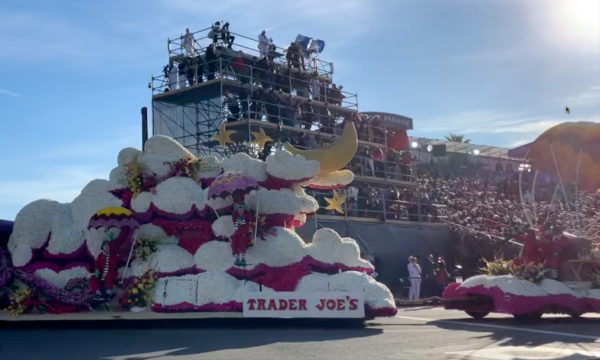 Float riders sit among "clouds" with "parachutes" above them on Trader Joe's float