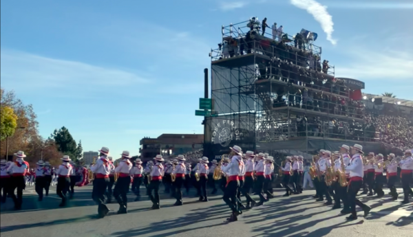 Costa Rican bandmembers in black slacks, red sashes and white shirts, play near the reviewing stand