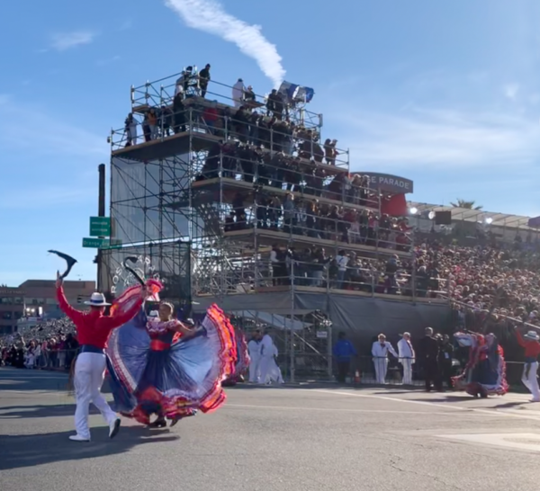 Two Costa Rican folk dancers perform a partner dance near reviewing stand