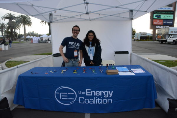 Jack and Jasmine smile in a long shot from the Energy Coalition booth