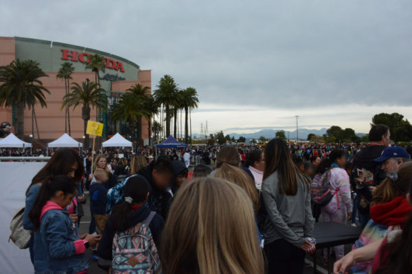 Crowds of students and teachers stand in the parking lot outside Honda Center for 2020 "First Flight Field Trip"