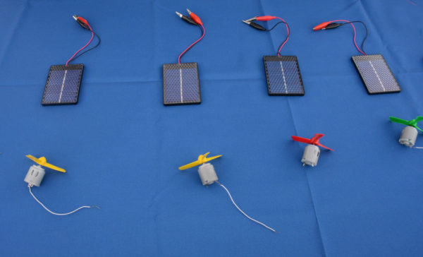 Multicolored USB-sized turbines sit on a table next to their power sources