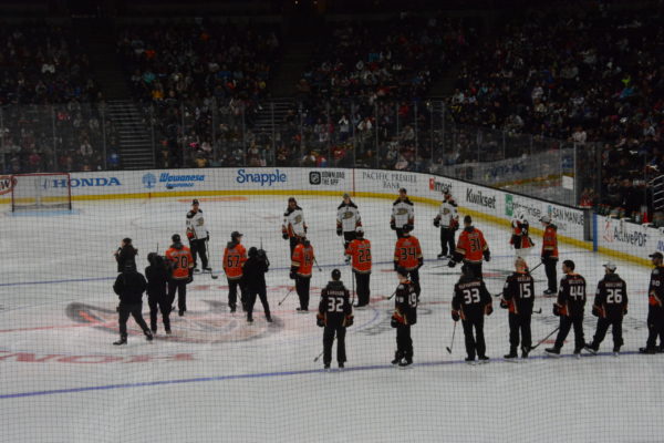 Ducks in three lines on ice with jerseys in white, orange and black